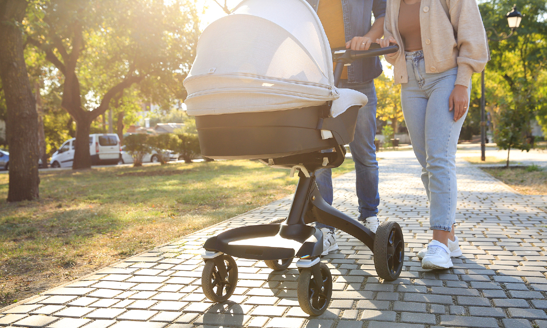 parents walking a pram in the park