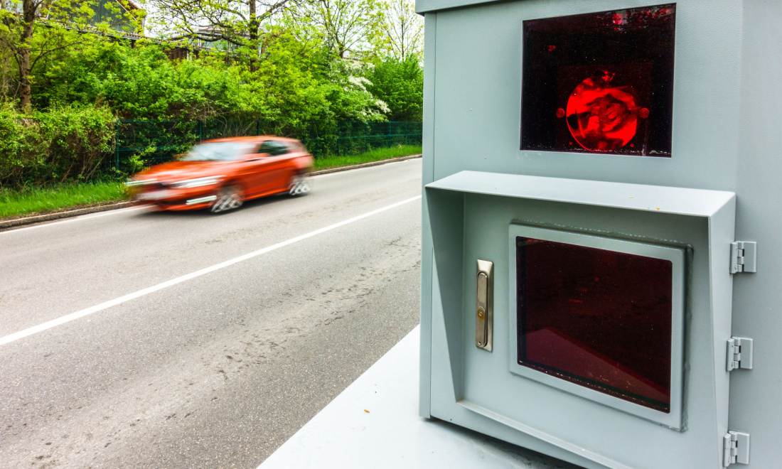 A speed camera catches a red car speeding in German countryside