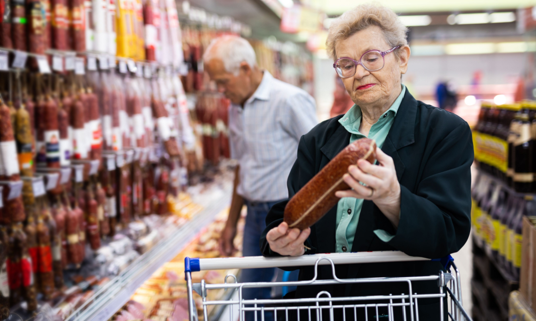 A woman looking at a salami in a German supermarket