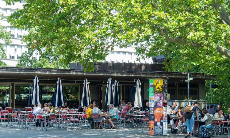Why do servers in Zurich prefer to speak English?