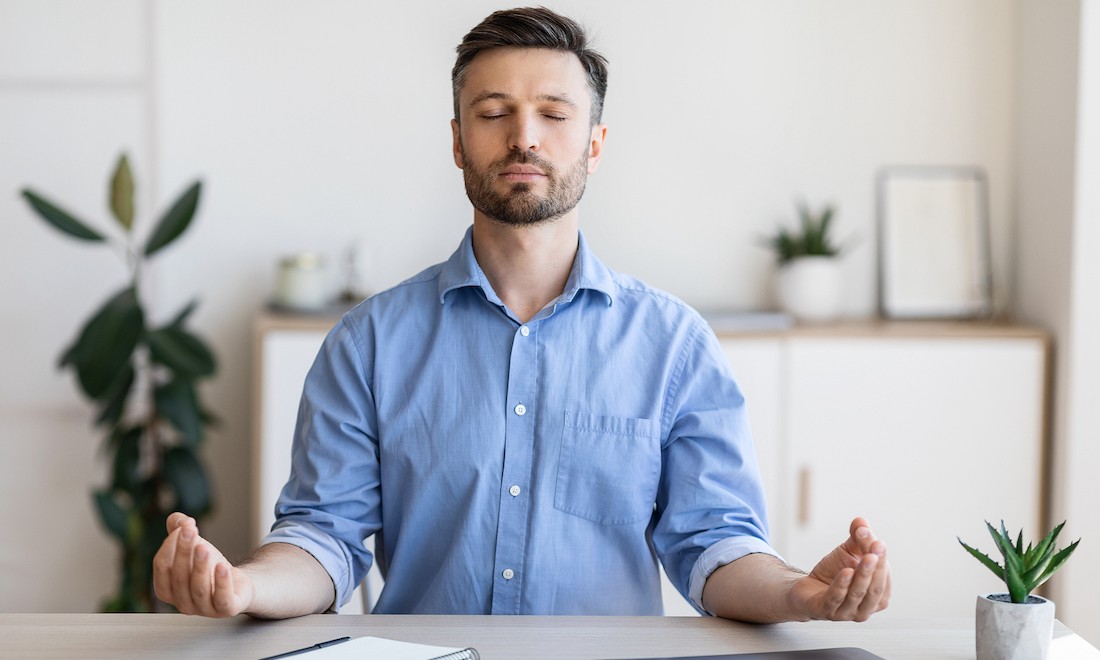 Man meditating at home to cope with stress