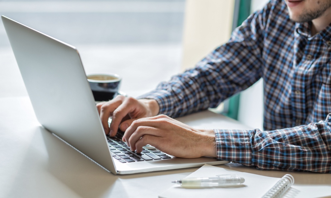 man typing on laptop